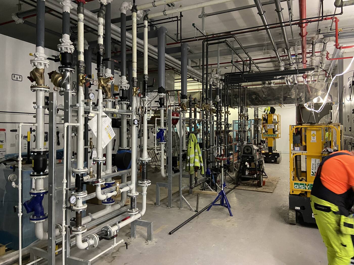 Installation af rør og ventiler i et teknikrum under opførelse